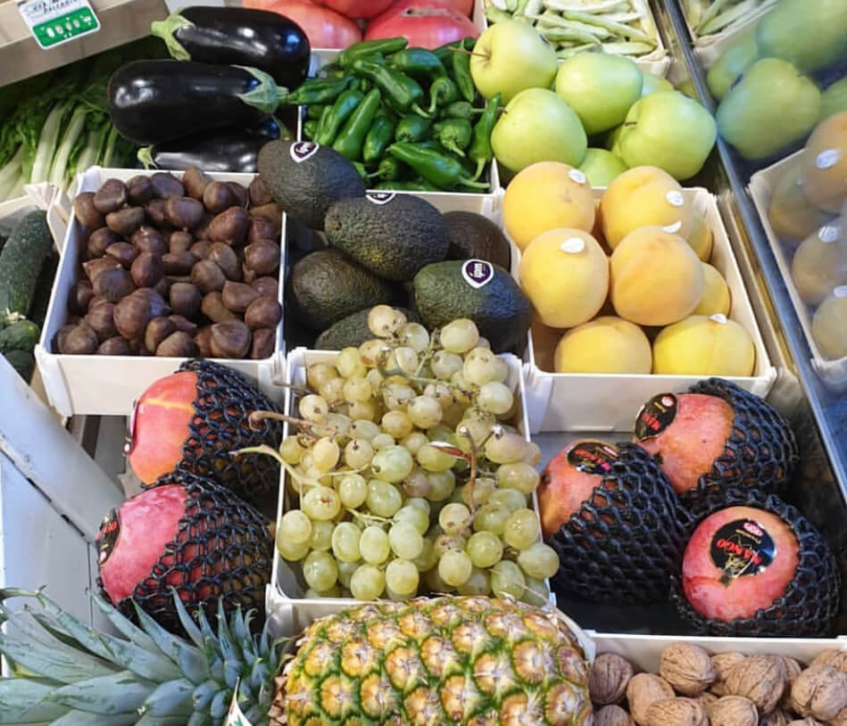 Cajas de madera Sincla con pitahayas, uvas, aguacates, piña y nueces en una frutería