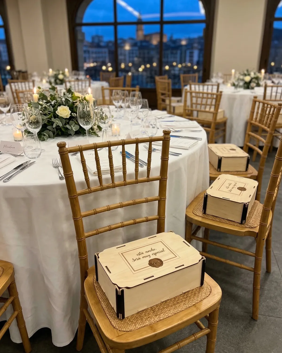 Banquete de boda con una caja de madera con tapa sobre cada silla