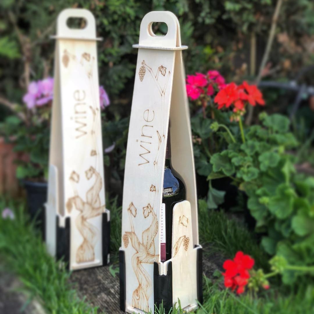 Dos cajas de madera para una botella vertical, con asa, la palabra «wine» y hojas de parra grabadas, entre flores